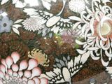 a close up of a vase with flowers painted on it