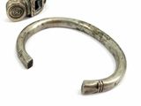 pair of antique silver bracelets with metal clasps on a white background