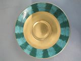 a green and gold plate on a white table