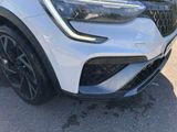 a close up of the front of a white car with black rims