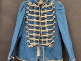 une vieille veste militaire bleue accrochée à un cintre au mur
