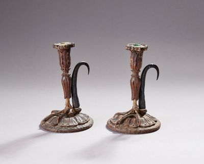 paire de bougeoirs en bronze représentant une femme tenant une fleur