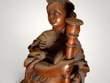 statue of a woman holding a candle in her right hand