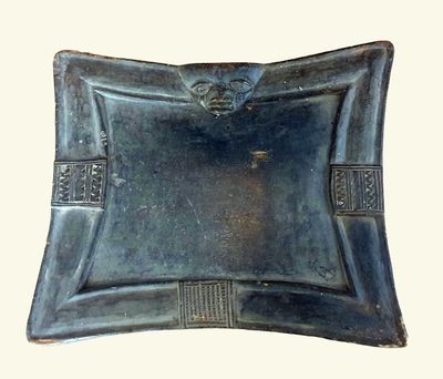 a metal tray with a decorative design on it