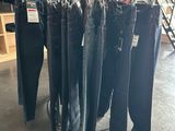 several pairs of jeans hanging on a rack in a clothing store