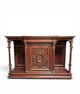 a wooden desk with a carved top and two shelves