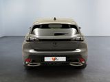 the rear end of a silver car in a white room