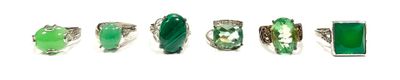 six different green and white rings with silver accents on a white background