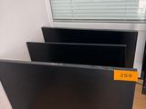 deux écrans posés sur un bureau, avec un téléphone devant eux