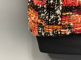 a close up of a multicolored bag on a mannequin
