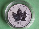 canadian silver maple leaf coin on a green surface