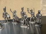 six figurines of soldiers on a metal surface