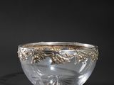 a silver and glass bowl on a black background