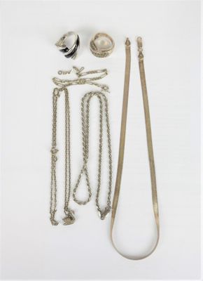 beaucoup de bijoux en argent sur une surface blanche