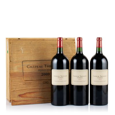 three bottles of red wine in front of a wooden box