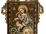 un cadre doré richement décoré, dans lequel se trouve un tableau représentant la Vierge à l'Enfant