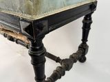 a small black stool with a green cushion on it