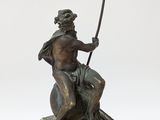 statue of a man sitting on a rock with a spear in his hand