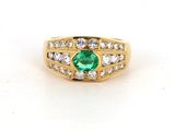 a close up of a ring with a green stone surrounded by diamonds