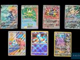 Les cartes Pokémon sont alignées sur une surface noire.