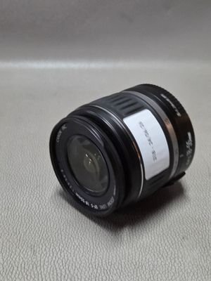 un objectif d'appareil photo noir posé sur une surface blanche