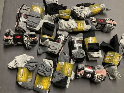 de nombreuses paires de chaussettes grises et noires posées sur une table