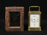 a small clock sitting next to a smaller clock on a table