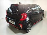 the back end of a small black car parked in a white room