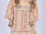 une poupée à l'ancienne, coiffée d'un chapeau et vêtue d'une robe, posée sur un fond blanc