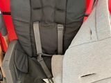 the baby seat has a grey cover on it and is attached to the back of the stroller