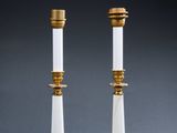 a pair of white and gold candles sitting on top of a table