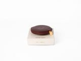 un petit biscuit au chocolat posé sur une boîte blanche