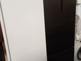 un réfrigérateur noir et blanc à côté d'un lave-linge et d'un sèche-linge