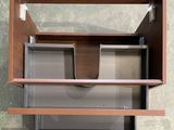 a wooden shelf with a glass door and a cup on it