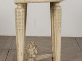 an old wooden table with a marble top on a wooden floor