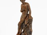 une image représentant la statue d'un homme assis sur une souche d'arbre