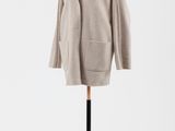 un manteau beige posé sur un mannequin, sur fond blanc