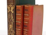 trois livres sont empilés sur une surface blanche