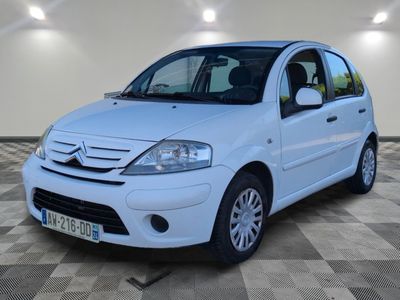 la petite voiture blanche est garée sur un carrelage à carreaux