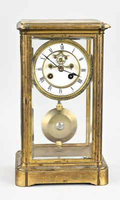 a gold clock with a glass case on top of it