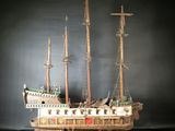 a wooden model of a ship on display on a table