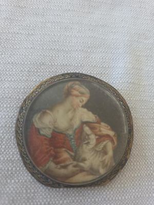 an old picture of a woman holding a cat in her lapel