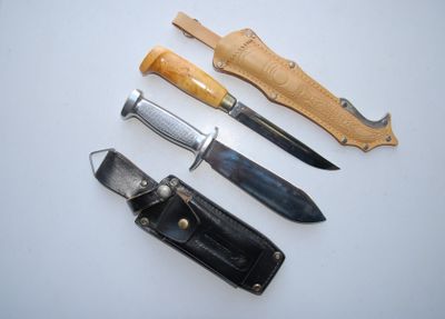 several different types of knives are lined up on a white surface