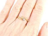 a woman ' s hand with a gold ring on it
