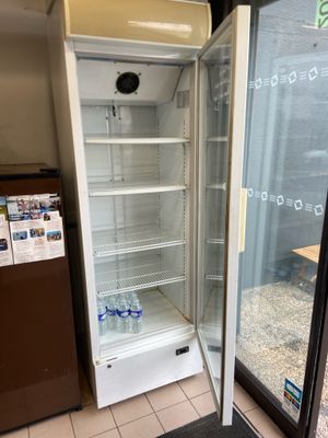 an empty refrigerator in the corner of a store
