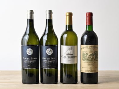 trois bouteilles de vin sont alignées sur une table en bois