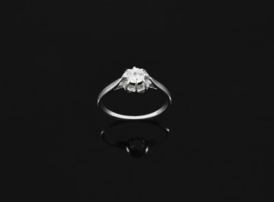 black and white photograph of a diamond ring on a black surface