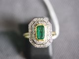 a close up of a ring with a green stone in it