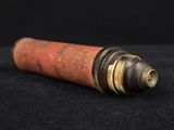 a close up of a red and black pipe on a black surface