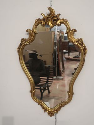 a mirror hanging on the wall with a bench in front of it